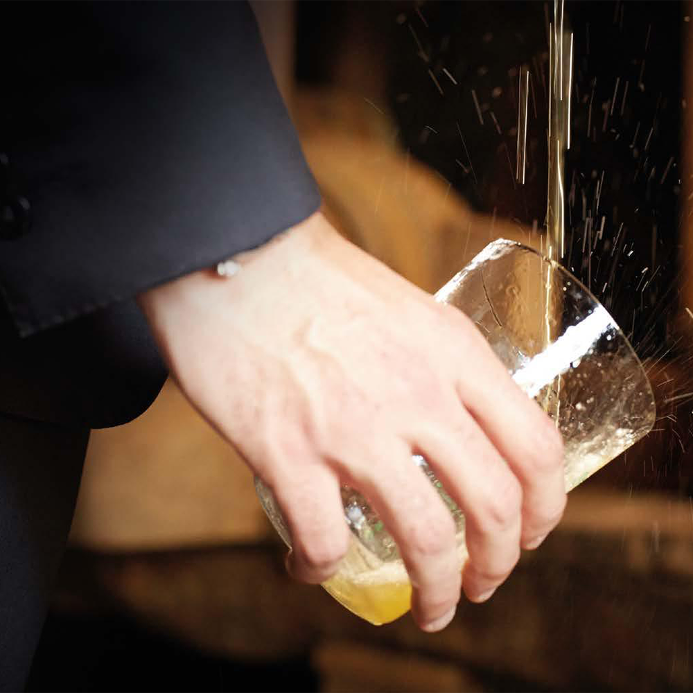 Camarero escanciando sidra en un vaso de sidra de cristal fino Sella 50 cl